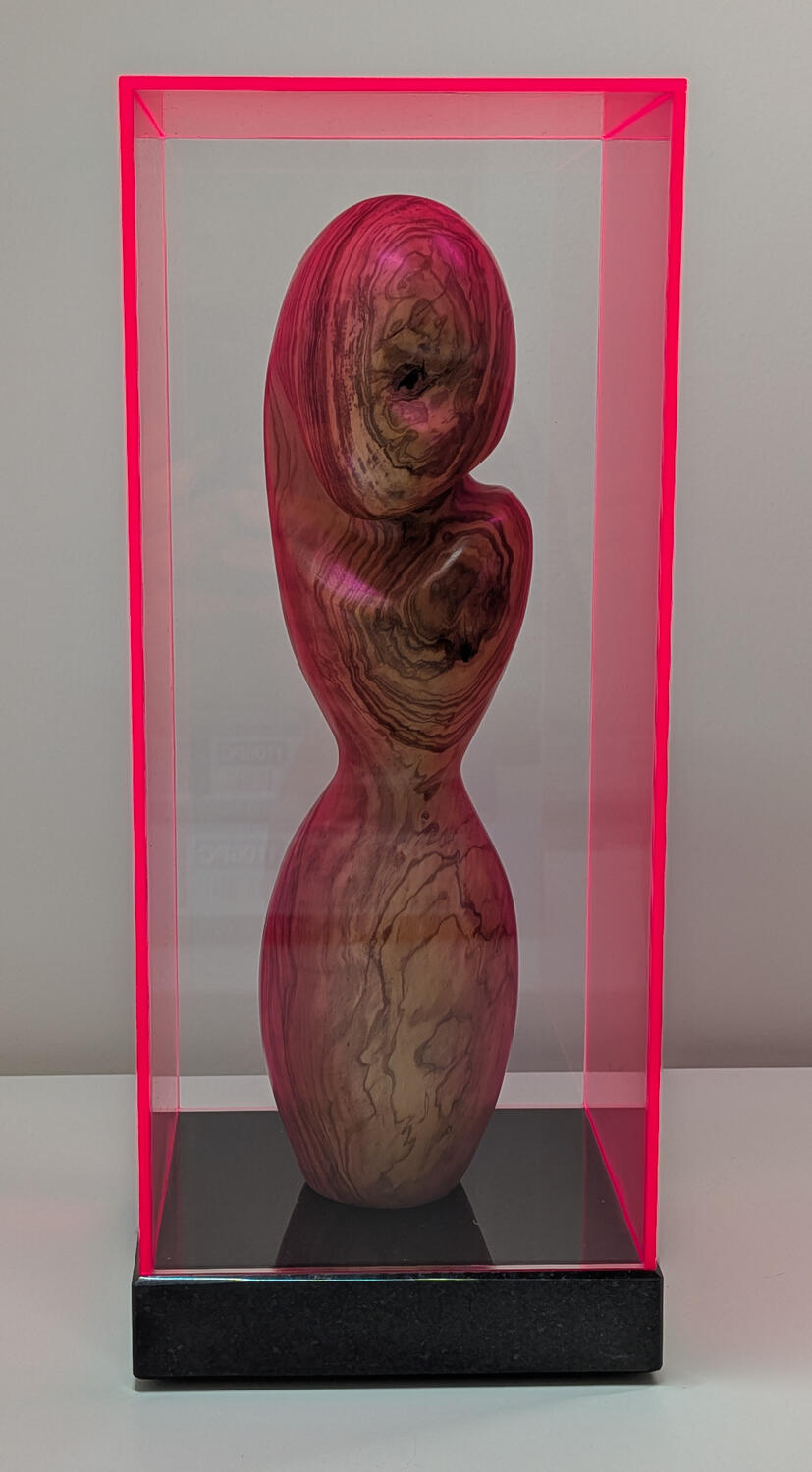 Den Erte-Ziener (De Harteziener) ...terwijl de barst een kwetsbaar hart blootlegt. Venitiaans Olijfhout op hardstenen sokkel (Fluo Rode Plexi stolp) | Status: Beschikbaar